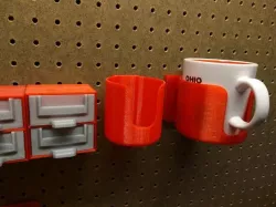 Pegboard mounted coffee cup holder