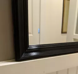Stick-on frame for bathroom mirror