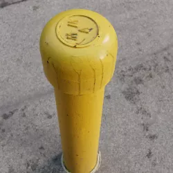 Yellow freshly painted parking post (bollard).