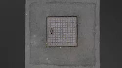 Square manhole cover rusty in asphalt