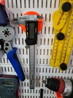 Caliper holder for Elfa pegboard.