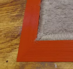 Wheel-friendly, sloped carpet edge frame (anti corner lift)