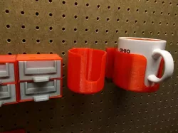 Pegboard mounted coffee cup holder