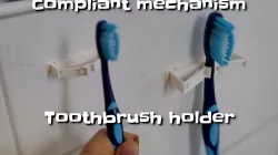 Compliant mechanism toothbrush holder