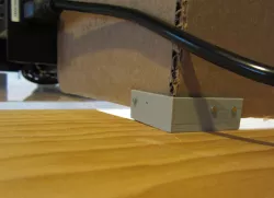 Bracket for a cardboard draft shield