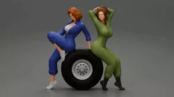 Two sexy girls in mechanic suits are sitting on a truck tire