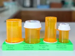 A Pill bottle stand for Two large, one medium and one small four Walgreens bottles