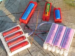 Flexing battery holders with integrated spring