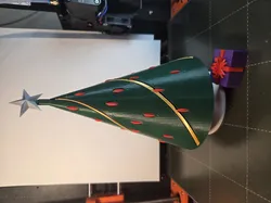 Christmas tree with spiral garland, & decorations with small present.