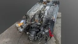 Silver car wreck upside down