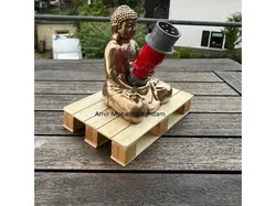 Ein goldener Buddha sitzt entspannt auf einer Palette – in seiner Hand hält er einen MENNEKES PowerTOP Stecker.